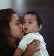 <p>Erny Khairul, mulher do engenheiro de voo Mohd Selamat, a bordo no avião desaparecido beija sua filha em hotel, onde esperam notícias sobre avião em Putrajaya</p>  Foto: Reuters