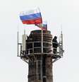 <p>Homens armados hasteiam a bandeira russa no topo de uma chaminé da base nava de Sebastopol - tomada pelos russos sem disparos na manhã da última quarta-feira</p>  Foto: Reuters