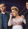 <p>Adrianne Haslet-Davis, ao lado do diretor Hugh Herr (à esquerda) e do parceiro Christian Lightner (à direita), se emociona após sua performance</p>  Foto: AP