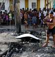 <p>Moradora recolhe destro&ccedil;os em meio &agrave; deflagra&ccedil;&atilde;o do confronto entre policiais e bandidos no Rio</p>  Foto: Daniel Ramalho  / Terra