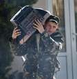Soldado ucraniano carrega uma televisão enquanto deixa a base militar de Belbek, perto de Sebastopol, Crimeia, nesta sexta-feira  Foto: AP