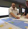 <p>Mike Barton (esq.), que comanda a equipe de resgate australiana, mostra a encarregado das operações um mapa da região em que as buscas são realizadas no Oceano Índico: 26 países estão envolvidos</p>  Foto: AP