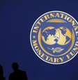 Silhueta de visitantes sobre o logotipo do Fundo Monetário Internacional, em Tóquio. O Fundo Monetário Internacional (FMI) reduziu nesta terça-feira sua projeção de crescimento econômico para o Brasil em 2014 a 1,8 por cento, ante 2,3 por cento previstos no início do ano. 10/10/2012  Foto: Kim Kyung-Hoon / Reuters