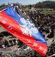 <p>A bandeira da chamada "República Federativa Donetsk" foi colocada em cima de uma barricada, e uma multidão de militantes pró-Rússia se reuniu em frente ao prédio da administração regional de Donetsk, nesta terça-feira, 8 de abril</p>  Foto: AFP