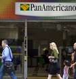 Pedestres passam em frente a uma unidade do Banco Pan Americano em São Paulo  Foto: Getty