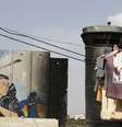 <p>Uma mulher lava roupa dentro de campo de palestinos refugiados em Aida, Cisjordânia</p>  Foto: Reuters