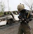 Soldado passa próximo a carro incendiado durante tiroteio na madrugada deste domingo na cidade ao leste da Ucrânia  Foto: Reuters