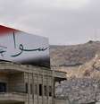 Cartaz com a assinatura do presidente e candidato Bashar al-Assad: campanha eleitoral em meio à guerra  Foto: AFP