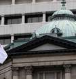 Bandeira do Japão em frente à sede do Banco Central do país, em Tóquio  Foto: Getty