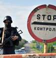 <p>Tropas ucranianas ficaram de guarda em um posto de controle na estrada perto da cidade oriental de Izum, região Donetsk; homens armados invadiram um quartel-general</p>  Foto: AFP