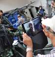 <p>Homem tirando foto de perto dos soldados nas ruas de Bangcoc, capital da Tail&acirc;ndia</p>  Foto: Rufus Cox / Getty Images 