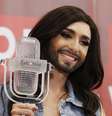<p>Conhita Wurst posa ao lado do seu troféu, recebido no concurso Eurovision. A "mulher barbada" foi acusada de ser a culpada sobre as enchentes na região dos Bálcãs</p>  Foto: Reuters