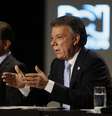 Óscar Zuluaga faz anotações enquanto escuta o presidente Juan Manuel Santos durante debate  Foto: AP