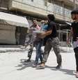 <p>Civis socorrem homem ferido durante bombardeios do regime de Assad a bairro de Aleppo, em 29 de maio</p>  Foto: Reuters
