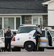 <p>Oficiais se escondem atrás de viatura em Moncton, New Brunswick, Canada, em 4 de junho</p>  Foto: Reuters