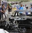 <p>Pessoas se reúnem em volta de um carro-bomba, perto de Basra. O carro explodiu perto da cidade xiita, nesta quarta-feira</p>  Foto: Reuters
