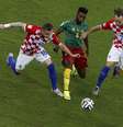 Song disputa bola com Rakitic e Olic em partida entre Croácia e Camarões, válida pelo Grupo A  Foto: Reuters