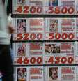 <p>Um homem caminha próximo a uma loja de de DVDs de segunda mão que exibe propaganda de vídeos pornográficos, em Tóquio, Japão, em 4 de junho</p>  Foto: AFP