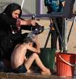  22 de junho - mulher iraquiana banha seu filho em um acampamento para deslocados iraquianos que fugiram de Mossul e outras cidades tomadas pelos insurgentes do Estados Islâmico e do Levante  Foto: AP