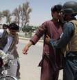<p>Policial afegão revista passageiros em um posto de controle na província de Helmand, em 25 de junho, quando mais de 800 insurgentes talibãs lançaram uma grande ofensiva no sul do Afeganistão para tentar ganhar território recentemente desocupado pelas tropas dos EUA</p>  Foto: Abdul Malik / AFP