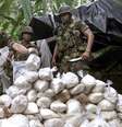 <p>Exército Mario Montoya (à esq.) examina um pacote de cocaína confiscado por tropas colombianas</p>  Foto: Eliana Aponte / Reuters