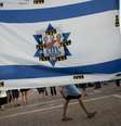 <p>No centro de uma bandeira de Israel, fotos dos três jovens desaparecidos são coladas em memória deles</p>  Foto: Oded Balilty / AP