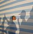 <p>Palestino observa, através de uma folha de tecido, um acampamento de verão organizado pelo movimento Hamas</p>  Foto: Mohammed Salem / Reuters