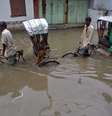 <p>Pessoas caminham em uma rua inundada após pesadas chuvas em Agartala, capital do estado de Tripura, nordeste da Índia, em 11 de junho. A região é afetada por um surto de Malária</p>  Foto: Jayanta Dey / Reuters
