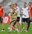 <p>Podolski chuta a bola em treinamento de reconhecimento de gramado da equipe alemã, antes de enfrentar o Brasil</p>  Foto: Peter Powell.jpg / EFE