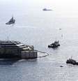 <p>Forro do cruzeiro Costa Concordia é cercado por rebocadores durante uma operação de resgate na Ilha de Giglio, em 14 de julho</p>  Foto: Alessandro Bianch / Reuters