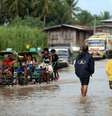 <p>Moradores cruzam&nbsp;uma estrada inundada em Mindanao, nas Filipinas, em&nbsp;15 de julho</p>  Foto: Jeoffrey Maitem / Getty Images 