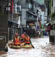 <p>Equipes de resgate procuram pessoas por uma rua inundada, após chuvas fortes atingirem a cidade antiga de Fenghuang County, província de Hunan, nesta quarta-feira, 16 de julho</p>  Foto: Reuters