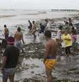 Moradores à beira-mar após a passagem do tufão Rammasun, no litoral da cidade de Rosário, ao sul de Manila. 16/06/2014.  Foto: Erik De Castro / Reuters