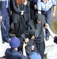<p>Daniel Corogeanu e duas freiras são escoltados por policiais durante a saída de um tribunal da Romênia, em 24 de junho de 2005</p>  Foto: ADU ANECULAESI / AFP