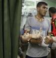 Bebê palestino é carregado em hospital após ser retirado de escola da ONU usada como abrigo por refugiados palestinos que foi atacada por artilharia na Faixa de Gaza. 24/7/2014.  Foto: Mohammed Salem / Reuters