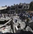 <p>Palestinos se reúnem em torno de casas destruídas, que, segundo testemunhas, foram atingidas em um ataque aéreo israelense, em Khan Younis, no sul da Faixa de Gaza, em 30 de julho</p>  Foto: Ibraheem Abu Mustafa / Reuters