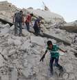 <p>Meninos seguram armas de brinquedo e brincam sobre os escombros de edifícios destruídos em Maarat Al-Nouman, ao sul de Idlib, na Síria, em 29 de julho</p>  Foto: Rasem Ghareeb / Reuters