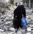 <p>Palestinas caminham sobre destro&ccedil;os de casa em Rafah que, segundo testemunhas, foram destru&iacute;das por ataque de Israel</p>  Foto: Ibraheem Abu Mustafa / Reuters