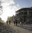 <p>Palestinos caminham diante de pr&eacute;dios destru&iacute;dos na Cidade de Gaza, em 6 de agosto</p>  Foto: Finbarr O'Reilly / Reuters