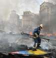<p>Um bombeiro extingue um inc&ecirc;ndio causado pela queima de uma barricada na Pra&ccedil;a da Independ&ecirc;ncia, em Kiev,&nbsp;durante confrontos de residentes da capital ucraniana, neste s&aacute;bado, 9 de agosto</p>  Foto: SERGEI SUPINSKY / AFP