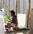 <p>Paciente com ebola é alimentada por um agente de saúde em Serra Leoa</p>  Foto: Dunlop/UNICEF / Reuters