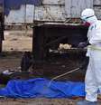 <p>O corpo de um homem encontrado na rua, com suspeita de morte pelo vírus ebola é pulverizado com desinfetante, em Monrovia, Libéria, em 12 de agosto</p>  Foto: Abbas Dulleh / AP