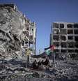 <p>Palestinos que perderam suas casas e seus estabelecimentos durante a ofensiva israelense sentam-se em um abrigo improvisado na cidade de Beit Lahiya, norte da Faixa de Gaza, em 11 de agosto</p>  Foto: Khalil Hamra / AP