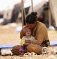 Mulher e criança da minoria yazidi, do Iraque, se refugiam em campo na Síria  Foto: Rodi Said / Reuters