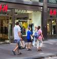Pedestres passam em frente a uma loja da grife H&M em Helsinque, na Finlândia  Foto: Tomi Setala/Getty Images