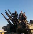 <p>Membros do grupo Estado Islâmico posam para foto no topo de um veículo militar com armas antiaéreas em Raqqa, na Síria</p><p> </p>  Foto: Raqqa Media Cente / AP
