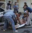 Ucranianos retiram homem ferido durante confrontos no centro da cidade de Donetsk  Foto: Maxim Shemetov  / Reuters