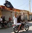 <p>Moradores de Tabqa erguem bandeira do Estado Isl&acirc;mico perto de Raqqa</p>  Foto: Stringer / Reuters