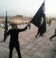 <p>Um integrante do Estado Isl&acirc;mico exibe&nbsp;uma bandeira do grupo terrorista em uma rua da cidade de Mossul, em 23 de junho</p>  Foto: Reuters