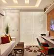SALA ÍNTIMA DO CASAL - Cyntia Sabat - Moderna e prática, a Sala Íntima do Casal, somada ao banheiro, possui 18m². Para integrar os espaços, conferindo a sensação de amplitude, uma cortina de vidro substitui a parede de alvenaria. Pensado para um casal que gosta de ler e praticar esportes, o ambiente conta ainda com uma estante multifuncional que serve tanto para guardar livros quanto raquetes e bolas  Foto: Divulgação